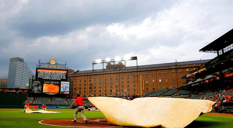 Groundskeepers cover home plate with a tarp during a rain delay Groundskeepers cover home plate with a tarp during a rain delay