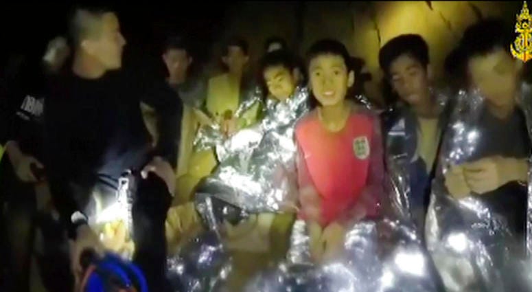 In this July 3, 2018, image taken from video provided by the Thai Navy Seal, Thai boys are with Navy SEALs inside the cave, Mae Sai, northern Thailand. Thai Cave Rescue