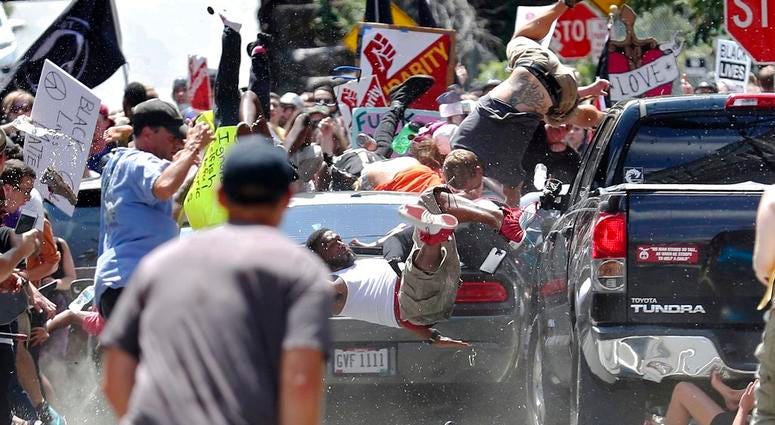 In this Aug. 12, 2017, file photo, people fly into the air as a vehicle drives into a group of protesters demonstrating against a white nationalist rally in Charlottesville, Va. In this Aug. 12, 2017, file photo, people fly into the air as a vehicle drives into a group of protesters demonstrating against a white nationalist rally in Charlottesville, Va.