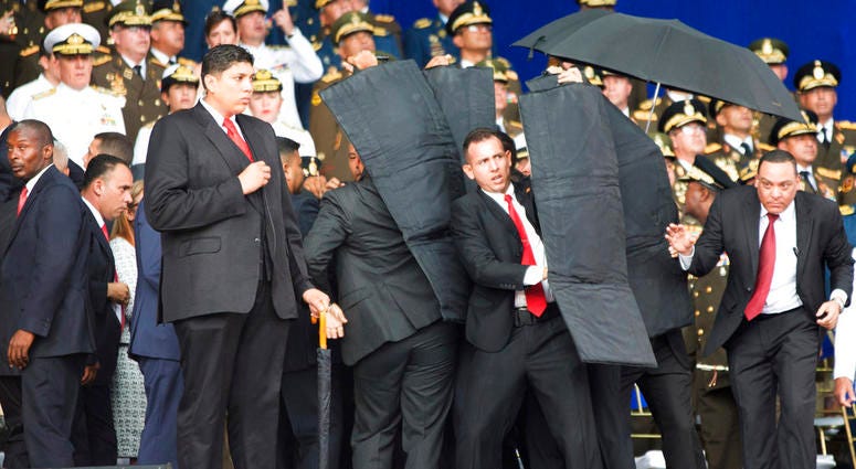 In this photo released by China's Xinhua News Agency, security personnel surround Venezuela's President Nicolas Maduro during an incident as he was giving a speech in Caracas, Venezuela, Saturday, Aug. 4, 2018. In this photo released by China's Xinhua News Agency, security personnel surround Venezuela's President Nicolas Maduro during an incident as he was giving a speech in Caracas, Venezuela, Saturday, Aug. 4, 2018.
