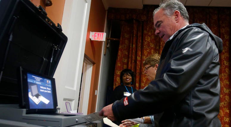 Sen. Tim Kaine, D-Va., feeds his ballot into the vote counting machine as he votes in Richmond, Va., Tuesday, Nov. 6, 2018. Sen. Tim Kaine, D-Va.
