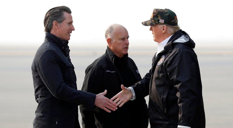 President Trump greets California Gov.-elect Gavin Newsom as he arrives on Air Force One at Beale Air Force Base for a visit to areas impacted by the wildfires as Gov. Jerry Brown stands at attention. President Donald Trump