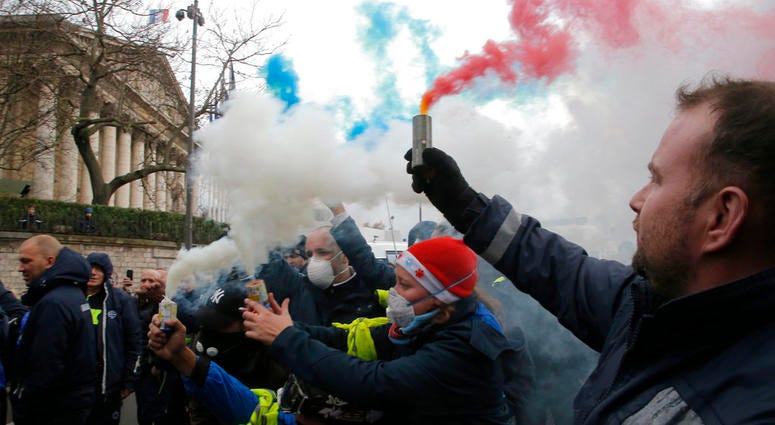 Ambulance workers hold flares outside the National Assembly in Paris, Monday, Dec. 3, 2018. Ambulance workers hold flares outside the National Assembly in Paris, Monday, Dec. 3, 2018.