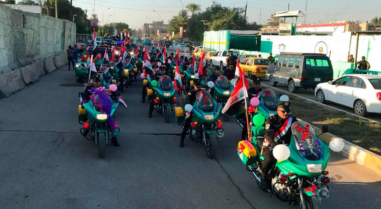 Iraqi security forces parade on motorcycles national flags marking the year anniversary of the defeat of the Islamic State group in Iraq in Tahrir Square, in central Baghdad, Monday, Dec. 10, 2018. Iraqi security forces parade on motorcycles national flags marking the year anniversary of the defeat of the Islamic State group in Iraq in Tahrir Square, in central Baghdad, Monday, Dec. 10, 2018.