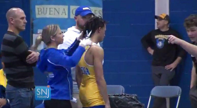 In this image taken from a Wednesday, Dec. 19, 2018 video provided by SNJTODAY.COM, Buena Regional High School wrestler Andrew Johnson gets his hair cut courtside minutes before his match in Buena, N.J., after a referee told Johnson he would forfeit his b In this image taken from a Wednesday, Dec. 19, 2018 video provided by SNJTODAY.COM, Buena Regional High School wrestler Andrew Johnson gets his hair cut courtside minutes before his match in Buena, N.J., after a referee told Johnson he would forfeit his b