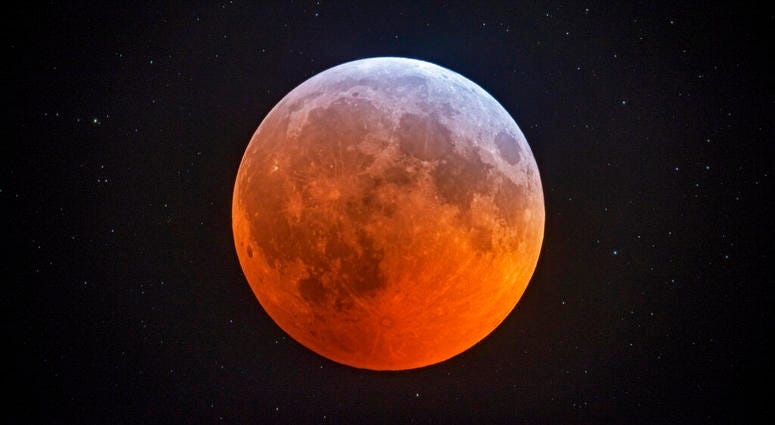 In this photo made with a 12-1/2 inch telescope and provided by Johnny Horne, the totally eclipsed moon glows with a reddish color against the background stars over Stedman, N.C., Monday, Jan. 21, 2019. The totally eclipsed moon glows with a reddish color against the background stars.