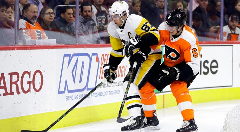 Pittsburgh Penguins' Sidney Crosby (87) and Philadelphia Flyers' Travis Sanheim (6) battle for the puck during the first period of an NHL hockey game, Monday, Feb. 11, 2019, in Philadelphia. Pittsburgh Penguins' Sidney Crosby (87) and Philadelphia Flyers' Travis Sanheim (6) battle for the puck during the first period of an NHL hockey game, Monday, Feb. 11, 2019, in Philadelphia.