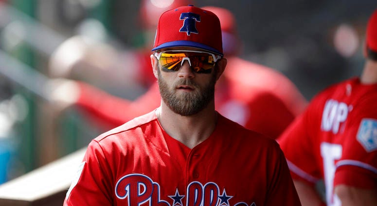 In this March 9, 2019 file photo Philadelphia Phillies' Bryce Harper waits his turn in the batting cage before a spring training baseball game against the Toronto Blue Jays in Clearwater, Fla. Bryce Harper