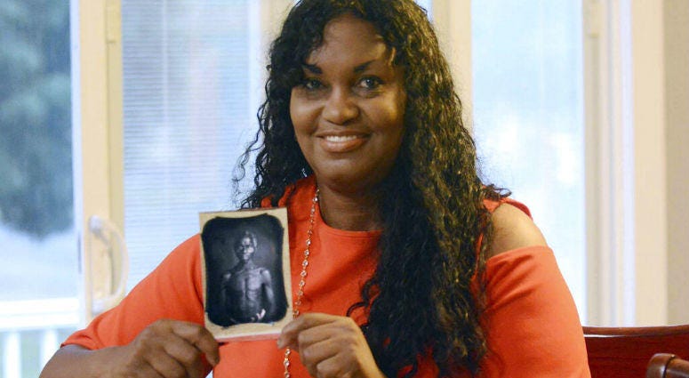 In this July 17, 2018, photo, Tamara Lanier holds an 1850 photograph of Renty, a South Carolina slave who Lanier said is her family's patriarch, at her home in Norwich, Conn. Tamara Lanier holds an 1850 photograph of Renty, a South Carolina slave who Lanier said is her family's patriarch, at her home in Norwich, Conn.
