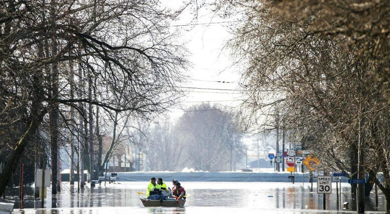 People on a boat float down floodwaters that cover Washington Street Wednesday, March 20, 2019, in Hamburg, Iowa. People on a boat float down floodwaters that cover Washington Street in Hamburg, Iowa.