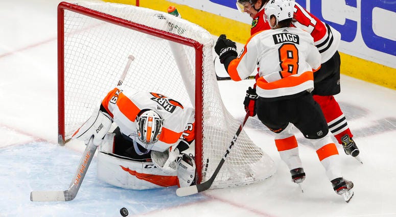 Chicago Blackhawks center Dylan Strome (17) tries to score against Philadelphia Flyers goaltender Carter Hart (79) and defenseman Robert Hagg (8) during the second period of an NHL hockey game Thursday, March 21, 2019, in Chicago. Philadelphia Flyers versus Chicago Blackhawks