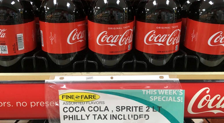 In this July 18, 2018, file photo, a sweetened beverage tax sign is posted by bottles of drinks at a supermarket in the Port Richmond neighborhood of Philadelphia. A sweetened beverage tax sign.