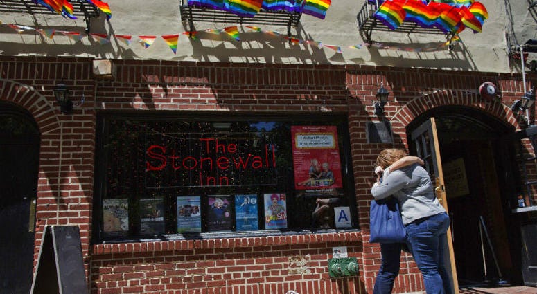 FILE- In this June 12, 2016 file photo, a couple embraces outside the Stonewall Inn in New York. On Thursday, June 6, 2019, Commissioner James O'Neill apologized for the 1969 police raid at the Stonewall Inn, which catalyzed the modern LGBT rights movement.