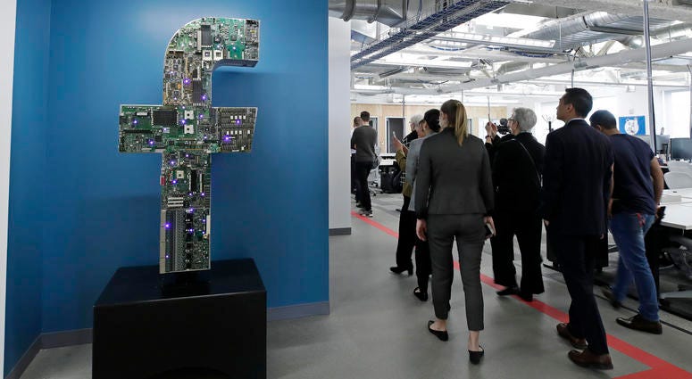 In this Jan. 9, 2019, file photo, media and guests tour Facebook's new 130,000-square-foot offices, which occupy the top three floors of a 10-story Cambridge, Mass., building. Facebook