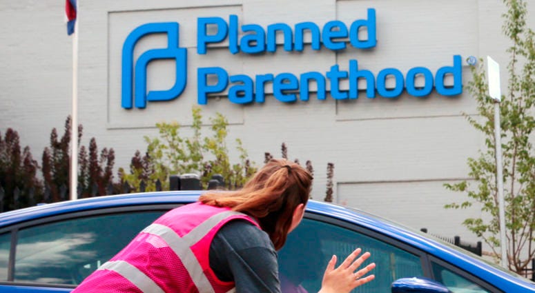 In this June 28, 2019 file photo, Ashlyn Myers of the Coalition for Life St. Louis, waves to a Planned Parenthood staff member in St. Louis, Mo. In this June 28, 2019 file photo, Ashlyn Myers of the Coalition for Life St. Louis, waves to a Planned Parenthood staff member in St. Louis, Mo.