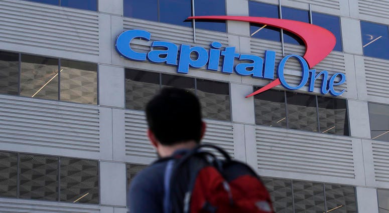 In this July 16, 2019, photo, a man walks across the street from a Capital One location in San Francisco. In this July 16, 2019, photo, a man walks across the street from a Capital One location in San Francisco.