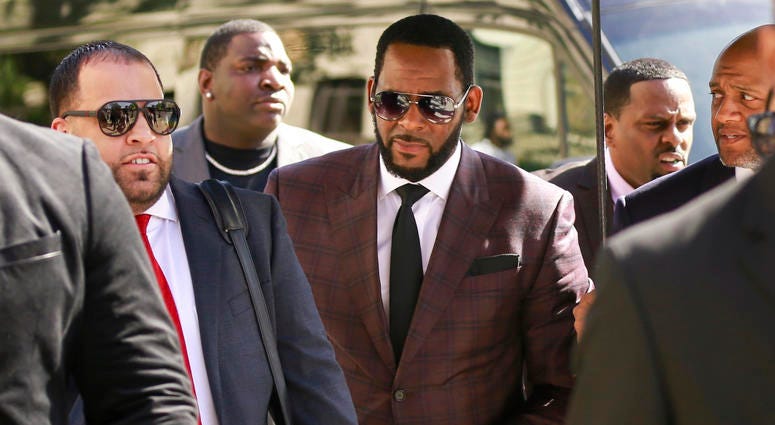 In this June 26, 2019, file photo, R&B singer R. Kelly, center, arrives at the Leighton Criminal Court building for an arraignment on sex-related felonies in Chicago. R. Kelly