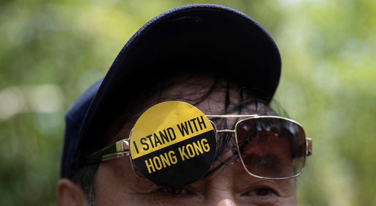 A man with a sticker that reads "I Stand With Hong Kong" on his glasses gathered with others in Lafayette Square in front of the White House, Aug. 18, 2019, in solidarity with the "Stand With Hong Kong, Power to the People Rally" in Hong Kong. Hong Kong