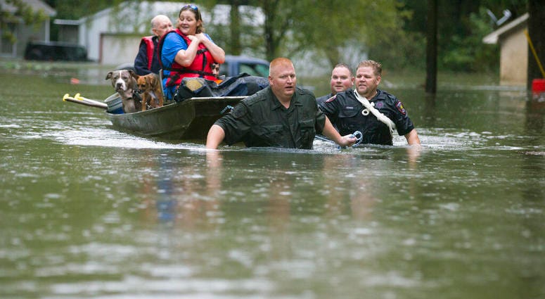 Splendora Police Lt. Troy Teller, left, Cpl. Jacob Rutherford and Mike Jones pull a boat carrying Anita McFadden and Fred Stewart from their flooded neighborhood inundated by rain from Tropical Depression Imelda on Thursday, Sept. 19, 2019, in Spendora, T Splendora Police Lt. Troy Teller, left, Cpl. Jacob Rutherford and Mike Jones pull a boat carrying Anita McFadden and Fred Stewart from their flooded neighborhood inundated by rain from Tropical Depression Imelda.