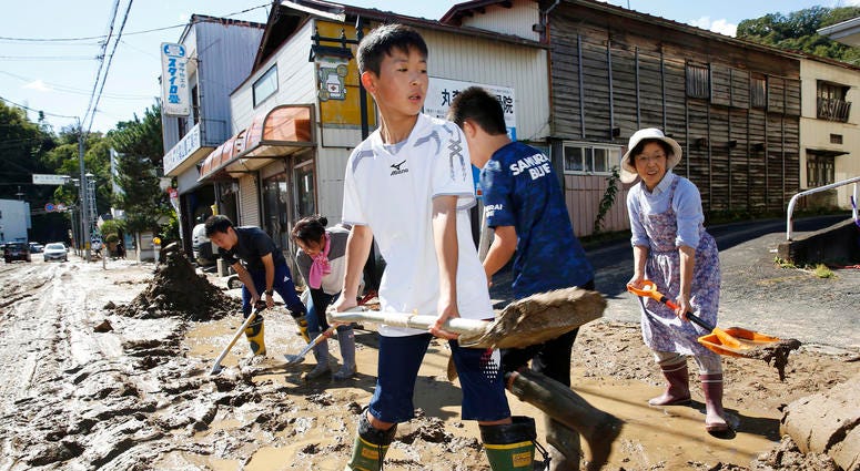 Rescue efforts for people stranded in flooded areas are in full force after a powerful typhoon dashed heavy rainfall and winds through a widespread area of Japan, including Tokyo. Students and residents scoop dirt as the town is flooded Typhoon Hagibis, in Marumori, Miyagi prefecture, northern Japan, Sunday, Oct. 13, 2019.