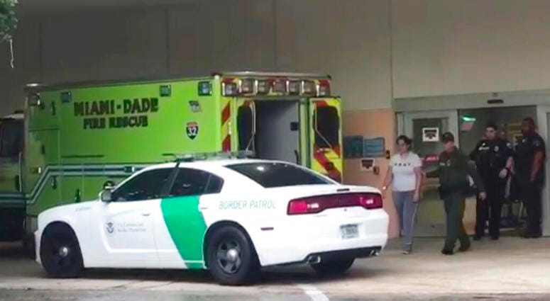 A border patrol agents escorts a woman to a patrol car Sunday, Oct. 13, 2019, at Aventura Hospital in Aventura, Fla. The woman had been detained by border patrol agents, when she fell ill. A border patrol agents escorts a woman to a patrol car Sunday, Oct. 13, 2019, at Aventura Hospital in Aventura, Fla. The woman had been detained by border patrol agents, when she fell ill.
