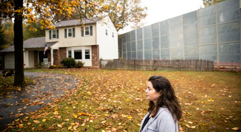 Carrie Gross walks past a construction barrier shielding the Mariner East pipeline near a home during an interview with The Associated Press in Exton, Pa. Carrie Gross walks past a construction barrier shielding the Mariner East pipeline near a home during an interview with The Associated Press in Exton, Pa.