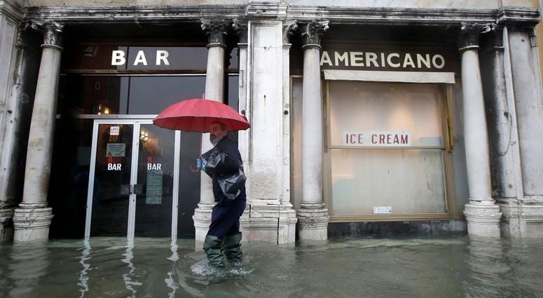 A man walks past a closed cafe in a flooded Venice, Italy, Tuesday, Nov. 12, 2019. A man walks past a closed cafe in a flooded Venice, Italy, Tuesday, Nov. 12, 2019.