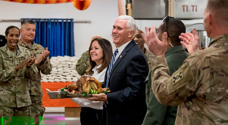 Vice President Mike Pence and his wife Karen Pence arrive with turkey to serve to troops at Al Asad Air Base, Iraq, on Saturday. The visit is Pence’s first to Iraq and comes nearly one year since President Donald Trump’s surprise visit to the country. Vice President Mike Pence and his wife Karen Pence arrive with turkey to serve to troops at Al Asad Air Base, Iraq, on Saturday.