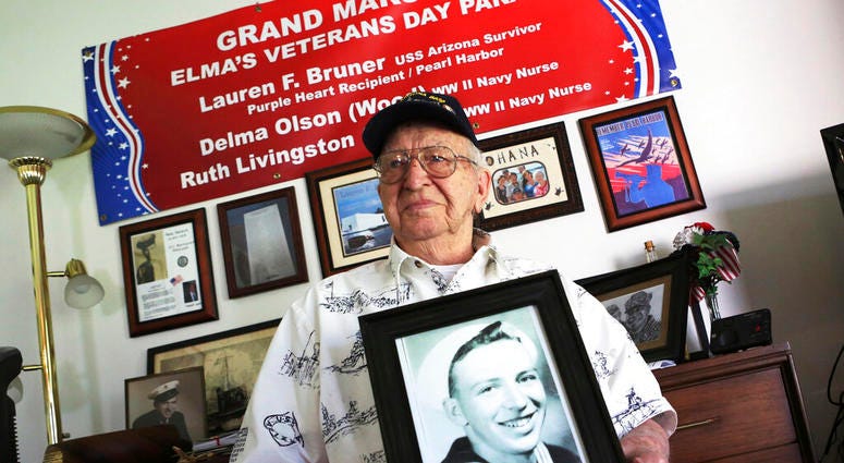 In this Nov. 17, 2016, file photo, Lauren Bruner, a survivor of the USS Arizona which was attacked on Dec. 7, 1941, holds with a 1940 photo of himself at his home in La Mirada, Calif. In this Nov. 17, 2016, file photo, Lauren Bruner, a survivor of the USS Arizona which was attacked on Dec. 7, 1941, holds with a 1940 photo of himself at his home in La Mirada, Calif.