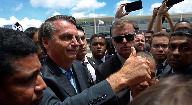 Brazil's President Jair Bolsonaro flashes a thumbs up as he greets supporters after attending a Changing of the Guard at the Planalto Presidential Palace, in Brasilia, Brazil, Thursday, Nov. 28, 2019. Brazil's President Jair Bolsonaro flashes a thumbs up as he greets supporters after attending a Changing of the Guard at the Planalto Presidential Palace, in Brasilia, Brazil, Thursday, Nov. 28, 2019.