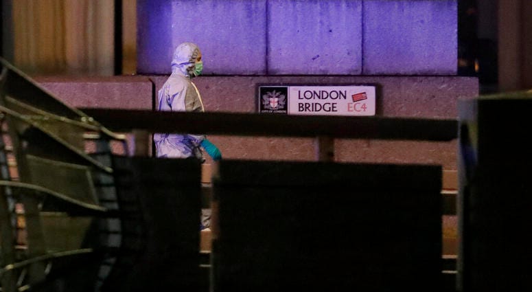 A police forensic officer walks by a sign where a man was shot dead by police on London Bridge following an incident in London. A police forensic officer walks by a sign where a man was shot dead by police on London Bridge following an incident in London.