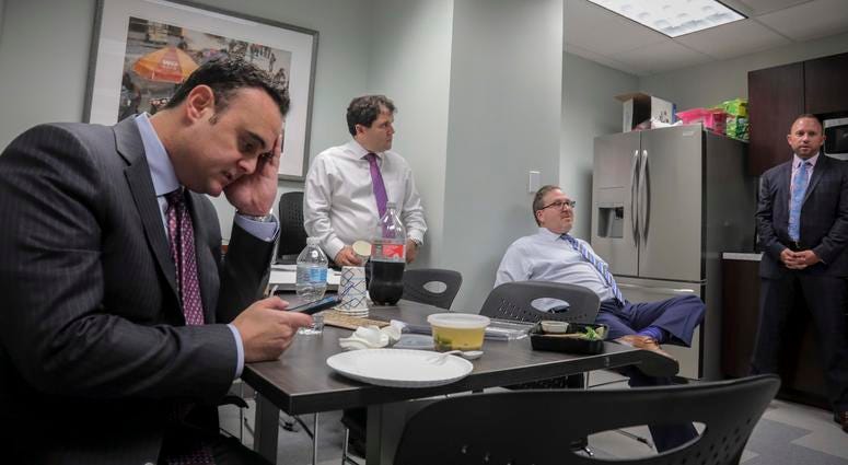 Attorney Adam Slater, left, checks his phone during a working lunch with lawyers in his firm. He said since New York opened its one-year window allowing sex abuse suits with no statute of limitations, his firm has signed up nearly 300 new clients. Attorney Adam Slater, left, checks his phone during a working lunch with lawyers in his firm.