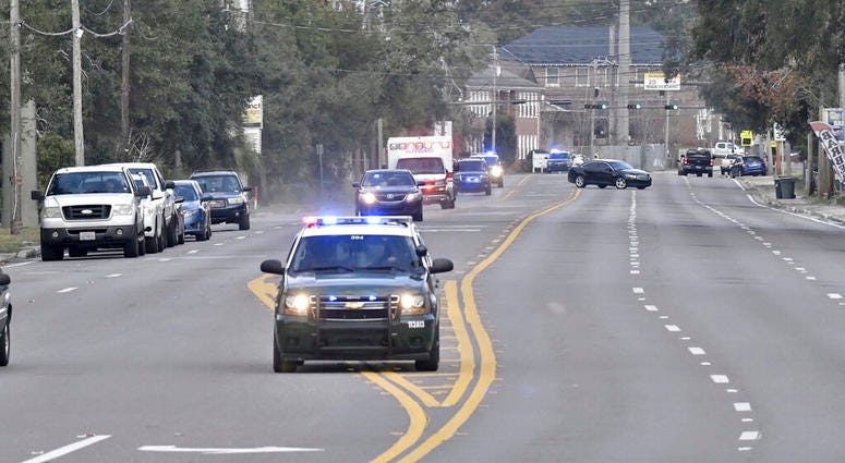 Police cars escort an ambulance after a shooter open fire inside the Pensacola Air Base, Friday, Dec. 6, 2019 in Pensacola, Fla. Police cars escort an ambulance after a shooter open fire inside the Pensacola Air Base, Friday, Dec. 6, 2019 in Pensacola, Fla.