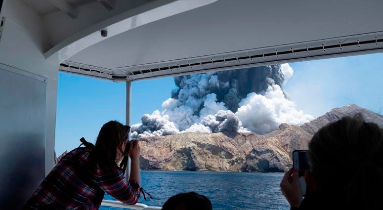 Tourists on a boat look at the eruption of the volcano on White Island, New Zealand, on Dec. 9, 2019. Tourists on a boat look at the eruption of the volcano on White Island, New Zealand, on Dec. 9, 2019.