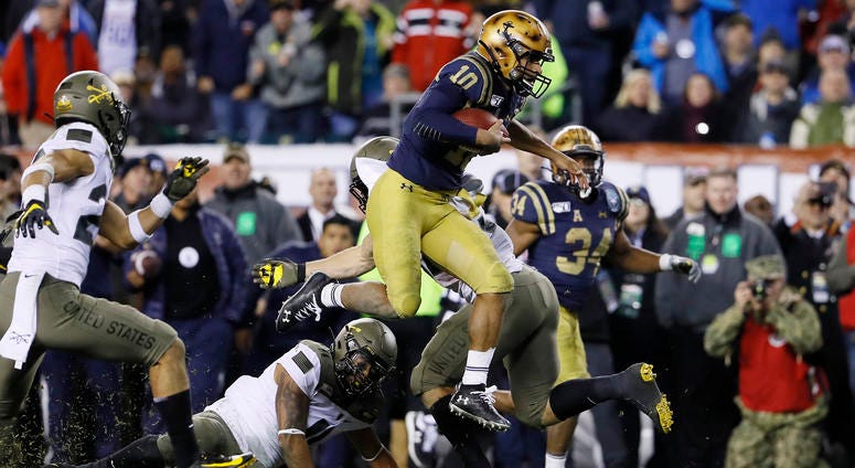 Navy's Malcolm Perry leaps over Army's Donavan Lynch during the second half of the Army-Navy Game. Navy's Malcolm Perry leaps over Army's Donavan Lynch during the second half of the Army-Navy Game.