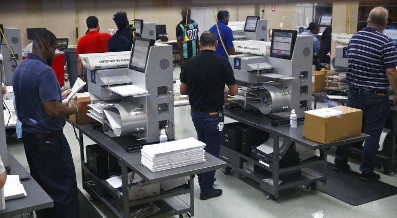 Workers load ballots into machines at the Broward County Supervisor of Elections office during a recount on Sunday, Nov. 11, 2018, in Lauderhill, Fla.
