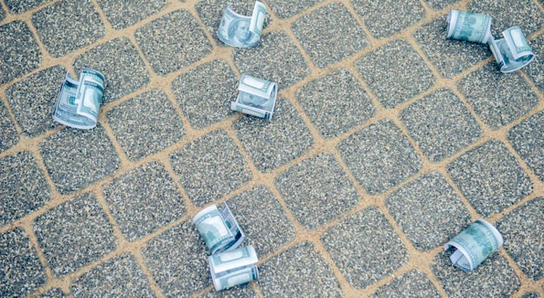 Dollar bills on asphalt road money of road