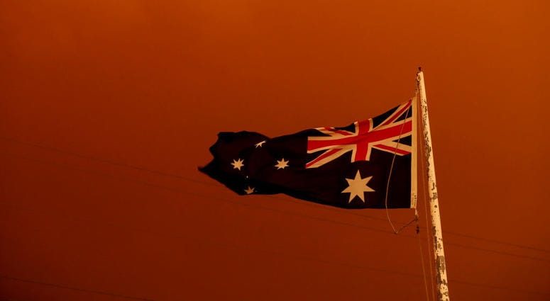 The Australia Flag flies under red skies from the fires on January 04, 2020 in Bruthen Australia. The Australia Flag flies under red skies from the fires on January 04, 2020 in Bruthen Australia.