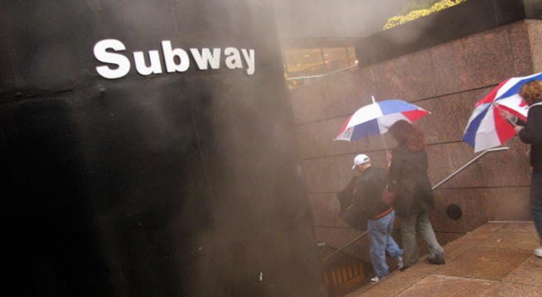 People enter a subway station on a wet and cold afternoon November 12, 2004 in New York City. New York City subway