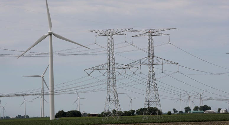 Power lines and power generating windmills rise above the rural landscape on June 14, 2018 near Dwight, Illinois. Power lines and power generating windmills