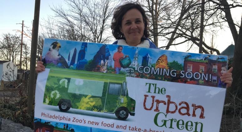 Kristen Waldron, director of strategic initiatives at the Philadelphia Zoo, holds a sign on the future site of The Urban Green. Kristen Waldron
