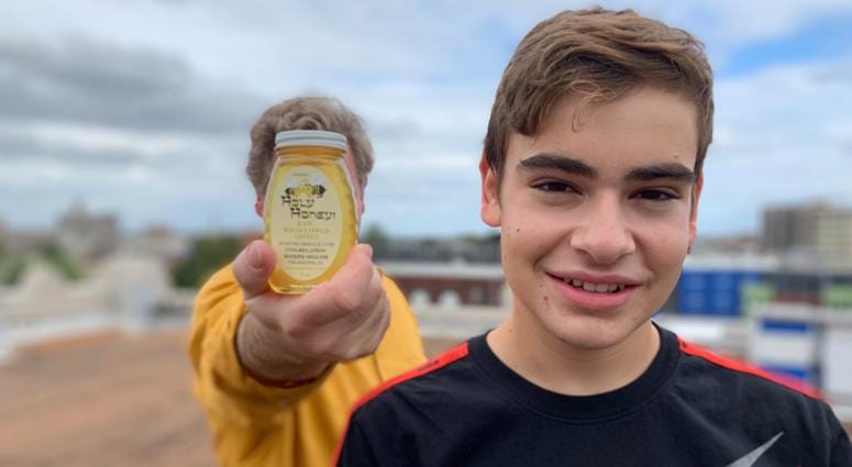Philadelphia Inquirer food critic Craig LaBan (background) displays Holy Honey with his son Arthur LaBan, cultivated atop Congregation Rodeph Shalom. Holy Honey