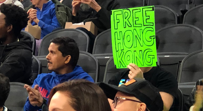Sam Wachs is shown holding a sign reading "Free Hong Kong." Sam Wachs is shown holding a sign reading "Free Hong Kong."