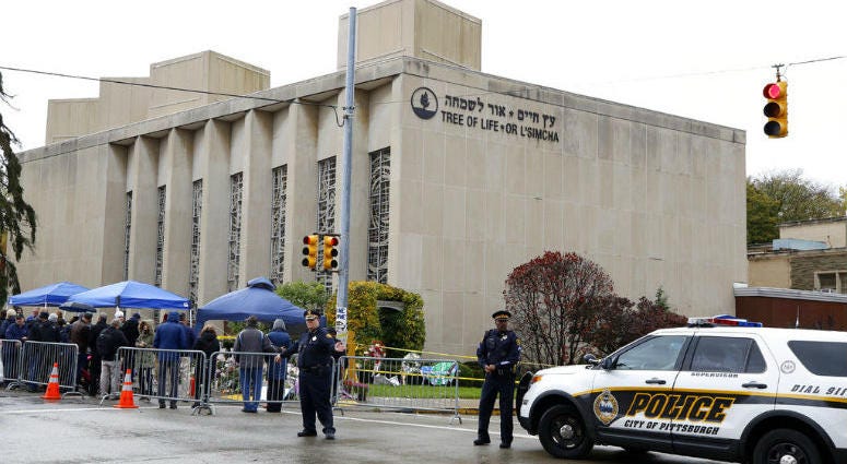Pittsburgh Police direct traffic as their vehicles close the street adjacent to the Tree of Life Synagogue on Saturday, Nov. 3, 2018, as a curbside Shabbat morning service is held on the street corner in the Squirrel Hill neighborhood of Pittsburgh.