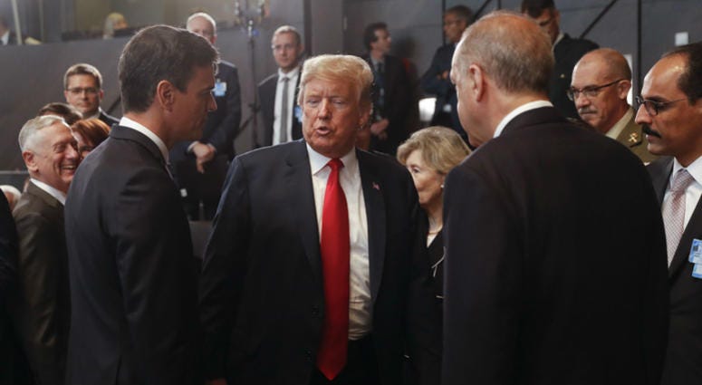 President Donald Trump, center, stops to talk with Spanish Prime Minister Pedro Sanchez, left, and Turkey's President Recep Tayyip Erdogan, right, as they attend a meeting of the North Atlantic Council. President Donald Trump, center, stops to talk with Spanish Prime Minister Pedro Sanchez, left, and Turkey's President Recep Tayyip Erdogan, right, as they attend a meeting of the North Atlantic Council.
