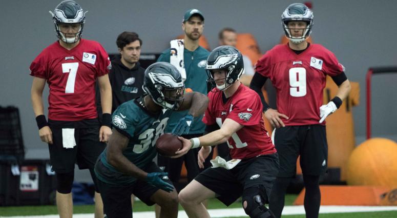 Philadelphia Eagles quarterback Carson Wentz (11) hands off to running back Matt Jones (38) in front of quarterback Nick Foles (9) and quarterback Nate Sudfeld (7) during organized team activities. Philadelphia Eagles quarterback Carson Wentz (11) hands off to running back Matt Jones (38) in front of quarterback Nick Foles (9) and quarterback Nate Sudfeld (7) during organized team activities.
