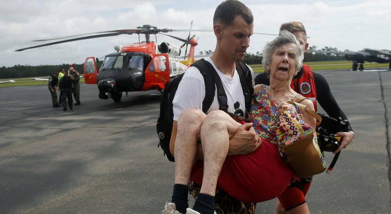 An unidentified family member carries Ruth Brady to safety at the Wilmington airport in Wilmington, N.C., Monday, Sept. 17, 2018. An unidentified family member carries Ruth Brady to safety at the Wilmington airport in Wilmington, N.C., Monday, Sept. 17, 2018.