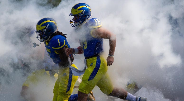 Delaware brings a 3-1 record into Saturday's battle with Pitt. Members of the University of Delaware Blue Hens running onto the football field.