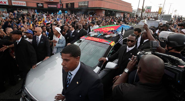 People watch as a hearse carrying the casket of slain rapper Nipsey Hussle passes Hussle's clothing store The Marathon, Thursday, April 11, 2019, in Los Angeles. Hussle’s casket, draped in the flag of his father’s native country, Eritrea in East Africa, e People watch as a hearse carrying the casket of slain rapper Nipsey Hussle passes Hussle's clothing store The Marathon, Thursday, April 11, 2019, in Los Angeles. Hussle’s casket, draped in the flag of his father’s native country, Eritrea in East Africa, e