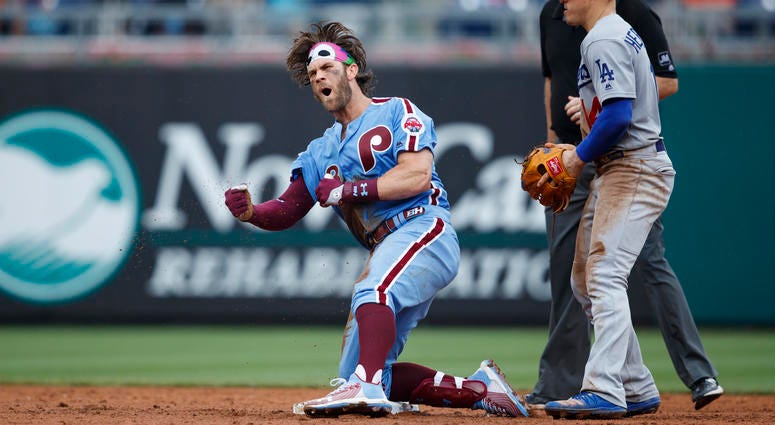 Philadelphia Phillies' Bryce Harper, left, celebrates past Los Angeles Dodgers shortstop Enrique Hernandez after hitting an RBI-single during the eighth inning of a baseball game, Thursday, July 18, 2019, in Philadelphia. Philadelphia won 7-6. Philadelphia Phillies' Bryce Harper, left, celebrates past Los Angeles Dodgers shortstop Enrique Hernandez after hitting an RBI-single during the eighth inning of a baseball game, Thursday, July 18, 2019, in Philadelphia. Philadelphia won 7-6.